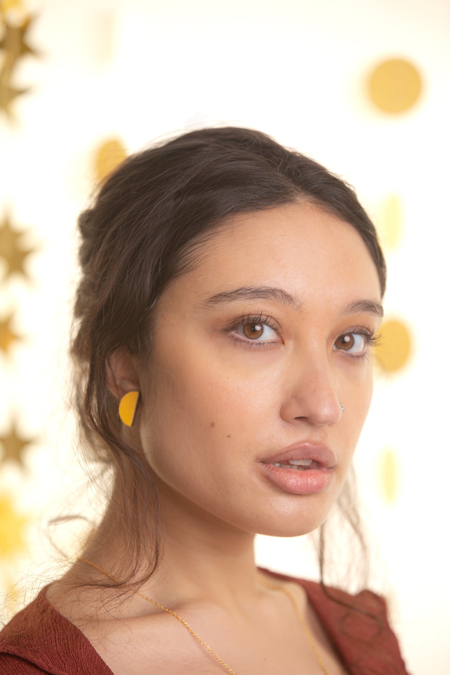 Woman wearing yellow earrings with a blurred background