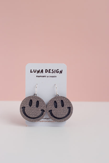 Smiley face earrings on a Luna Design card with a pink background